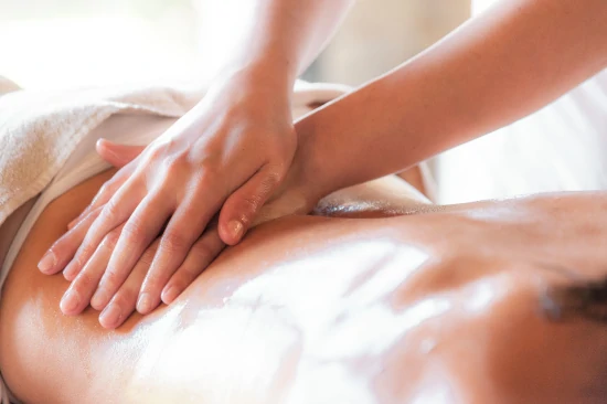 Massagem terapêutica aplicada por profissional na Clínica Márcia Domingos, na Barra da Tijuca